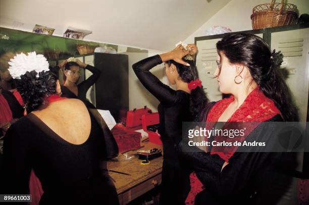 Flamenco dancers in a dressing room Three flamenco dancers put on make up and they comb in a dressing room