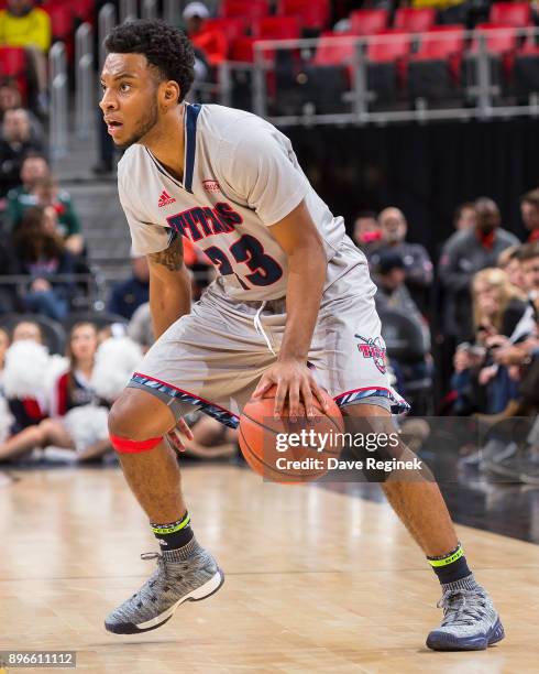 Josh McFolley of the Detroit Titans controls the ball against the Michigan Wolverines during game one of the Hitachi College Basketball Showcase at...