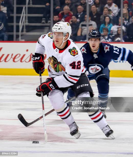 Gustav Forsling of the Chicago Blackhawks plays the puck up the ice during third period action against the Winnipeg Jets at the Bell MTS Place on...