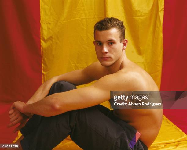 Martin Lopez Zubero, swimmer Sat down, with the torso naked, next to the flag of Spain