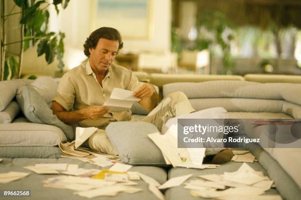 The singer Julio Iglesias at his home in Miami Sat down in an armchair reading letters