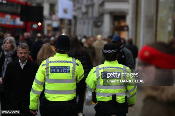 Members of the Metropolitan Police patrol amongst the shoppers on Oxford Street, in central London on December 21, 2017.