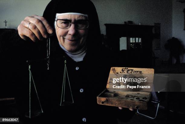 Nun with a scale A nun shows a scale of weighing money in the Convent of Closing of the Clarisas Sisters. Toledo