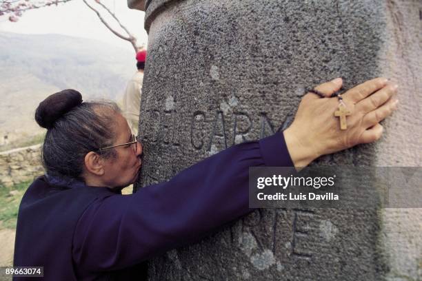 Pilgrimage in San Sebastian de Garabanda, Santander A faithfull kissing a headstone