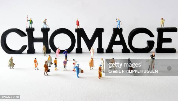 Photo prise le 07 août 2013 à Lille de figurines posées devant des lettres composant le mot "chômage". AFP PHOTO / PHILIPPE HUGUEN / AFP PHOTO /...