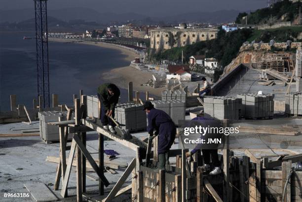 Santona. Cantabria ´Marsh of Santona´ Urban growth: workers working in a building in construction in front of the bay.