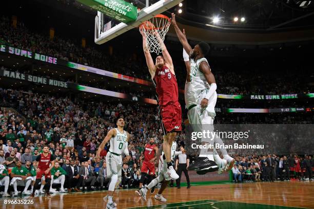 Kelly Olynyk of the Miami Heat dunks the ball around Kyrie Irving and Jaylen Brown of the Boston Celtics on December 20, 2017 at the TD Garden in...