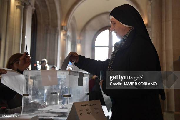 Nun casts her ballot for the Catalan regional election at a polling station in Barcelona on December 21, 2017. Catalans take their divisions over...
