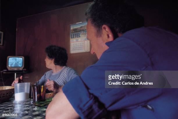 Couple eating on a table A couple of farmers eats seeing the television in her house of Vich . Barcelona province