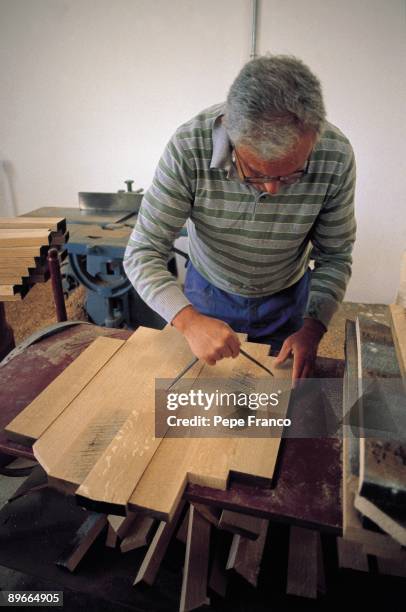 Wine barrels manufacture A man measures the wooden charts in a cooperage of Vega-Sicilia company in the Valladolid province