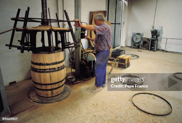 Wine barrels manufacture A man manages a machine that inserts barrels in a cooperage of Vega-Sicilia company in the Valladolid province