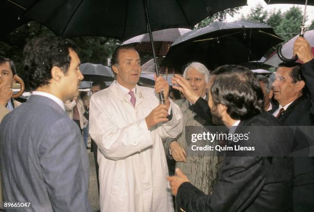 Juan Carlos I inaugurates the Fair of the Book of Madrid Juan Carlos I is protected of the rain under an umbrella in the presence of the mayor of...