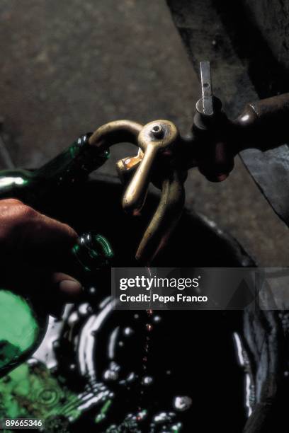 Bottled handy A man bottles the bottles of wine manually in Bodegas Lopez Heredia company. La Rioja province