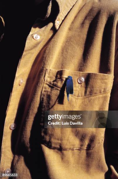 Blue knot Detail of a man with a blue knot, icon of solidarity, in his shirt during a demonstration of Gesto por la Paz