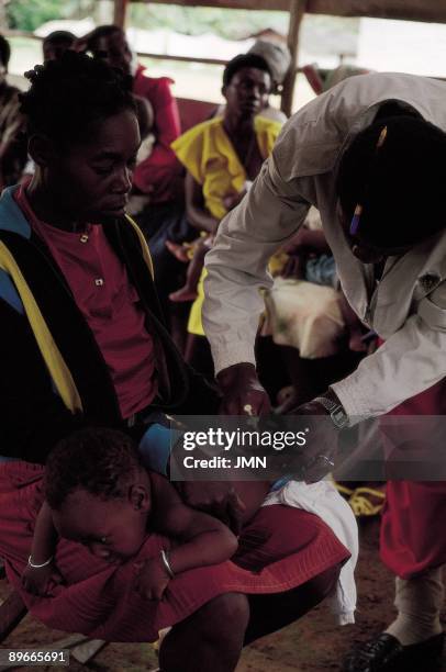 Doctor vaccinating a boy Doctor vaccinating a boy in poinn of health of the Ebon Nbama town