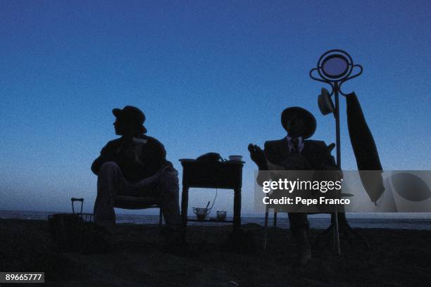 Men in a beach Two seated men with suit and tie on a beach