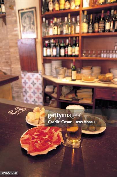 Casa Roman. Seville. Interior of a typical bar of ´tapas´ of the city with plates of ham and olives in the bar.