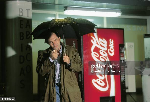 Pedro Piqueras, journalist Pedro Piqueras lights a cigarette under the rain