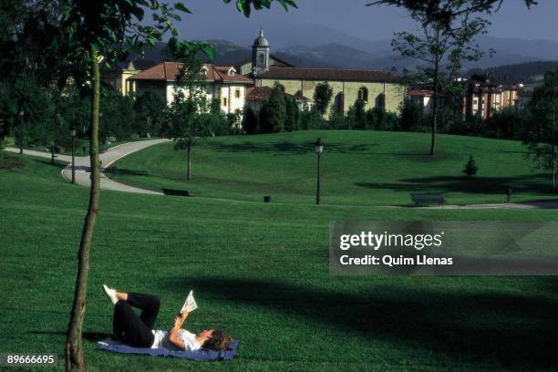 Europe park in Guernica A lying woman reads a book in the Park of Europe in Gernika, Biscay province