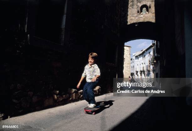 Boy on a skate Boy playing with a skate on a street of Verges. Gerona province