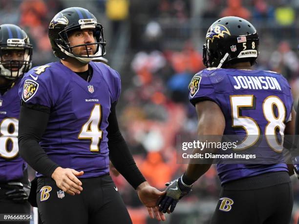 Punter Sam Koch of the Baltimore Ravens high fives linebacker Steven Johnson after downing a punt at the one yard line in the third quarter of a game...