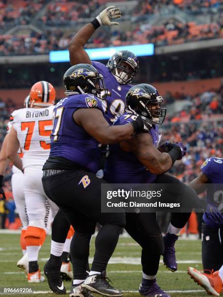 Defensive tackles Brandon Williams, Michael Pierce and Willie Henry of the Baltimore Ravens celebrate a fumble recovery for a touchdown by Williams...