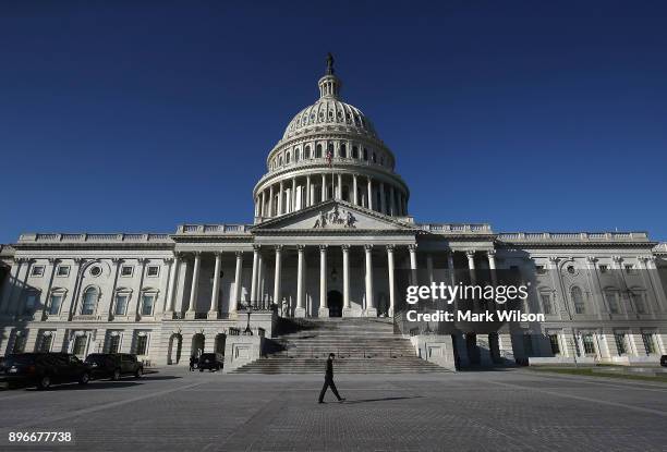 Pedestrian walks past the U.S. Capitol as congressional lawmakers work on a deal to fund the government and avert a shutdown by midnight Friday, on...