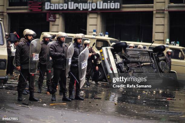 Riot police in a student demonstration in Madrid Riot policemen with shields and truncheons in a street fight during a demonstration against the...