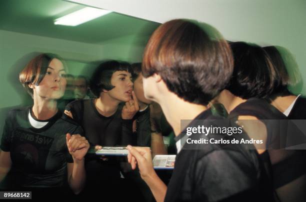 Women putting on makeup Three women put on makeup before a mirror