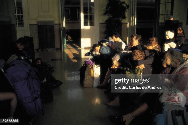 People in the waiting room of a railway station Several people sleeping and resting waiting room of a railway station