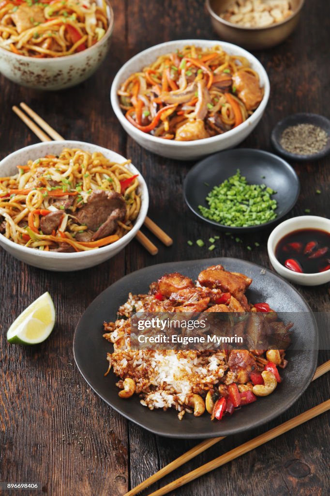 Bowls with chicken, beef and vegetables chow mein and rice with pork