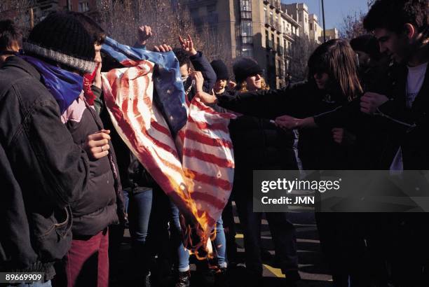 Students burning an American flag. A group of students burns an American flag during the student manifestation against the War of the Gulf in Madrid.