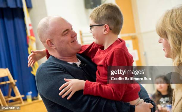 Army Master Sgt. Thomas Pardue embraces his son Ebin Pardue after surprising him by returning early from an Army deployment in Korea at Millersville...