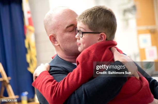 Army Master Sgt. Thomas Pardue embraces his son Ebin Pardue after surprising him by returning early from an Army deployment in Korea at Millersville...