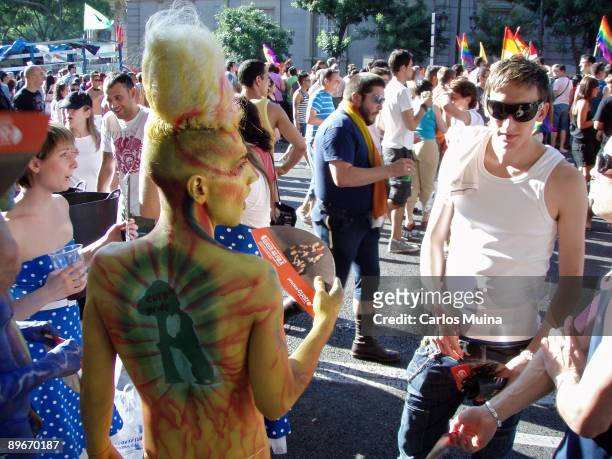 June 30, 2007. Madrid. Spain. Pride Parade celebration. In the photo, a man with a wig and in his back, a painting of the Madrid shield with a bear...