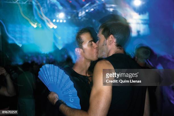Couple of gays kissing during the day of Gay Pride in the palace Vistalegre, Madrid