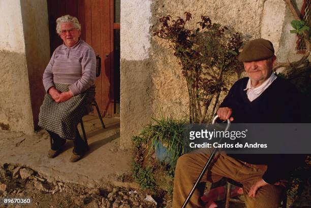 Olivenza, Badajoz . A couple of pensioners sunbathing at home´s door.