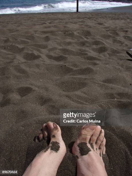 March 19, 2007. Playa del Hombre, Telde, Gran Canarias, Canary Islands, Spain. In the image, close up of a feet. On the rear, the waves of the sea.
