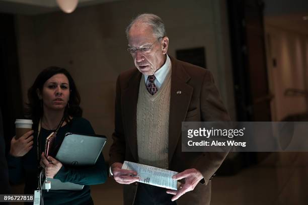 Sen. Chuck Grassley speaks to a reporter in a hallway December 21, 2017 on Capitol Hill in Washington, DC. Congress is trying to pass a short term...