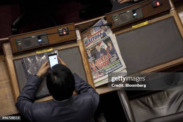 Congressman views a mobile device during a National Congress session with Pedro Pablo Kuczynski, Peru's president, not pictured, in Lima, Peru, on...