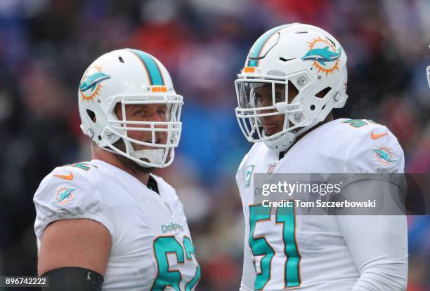 Ted Larsen of the Miami Dolphins talks to Mike Pouncey during a break in the action during NFL game action against the Buffalo Bills at New Era Field...