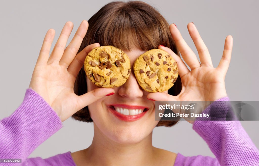 GIRL HOLDING CHOCOLATE CHIP COOKIES SMILING