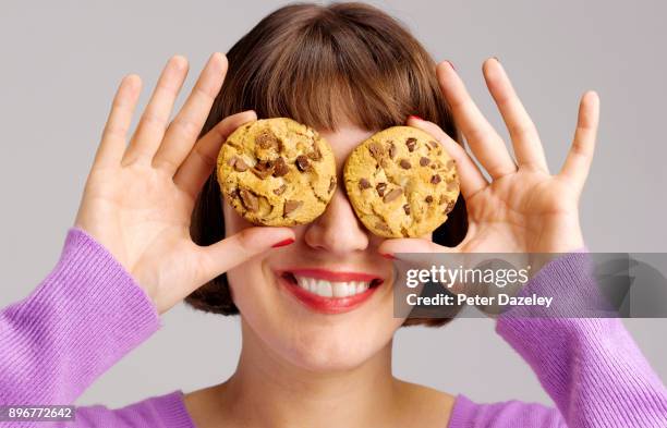 girl holding chocolate chip cookies smiling - chocolate chip cookies stock pictures, royalty-free photos & images