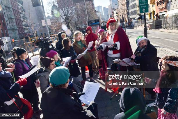 Andrew Bolotowsky with Santa Claus and members of Earth is Our Mother sing Christmas carols at Petronsino Square as part of "Make Music Winter,...