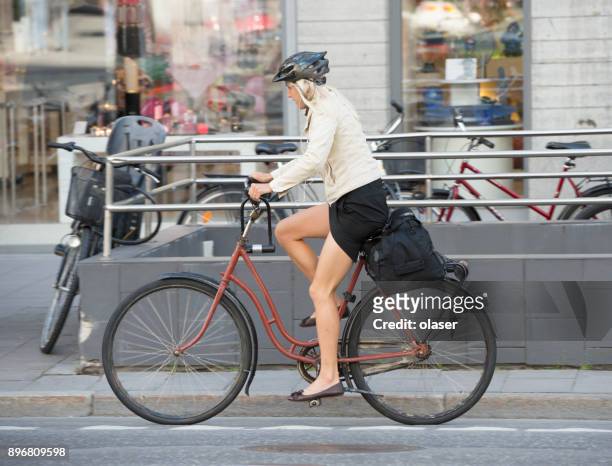 kvinna på cykel, trafik i bakgrunden - stureplan bildbanksfoton och bilder