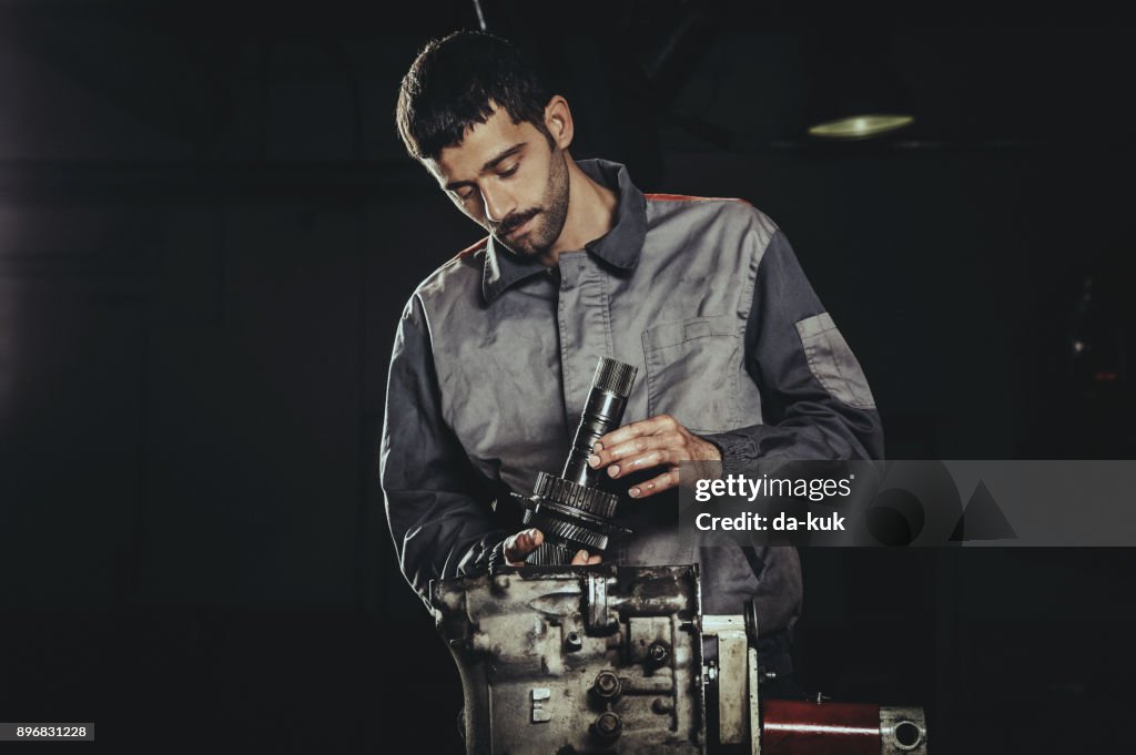 Mechanic repairing automatic transmission