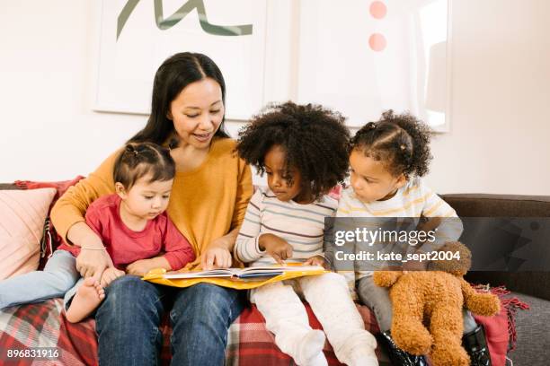 reading a book for toddlers - multilingual stock pictures, royalty-free photos & images