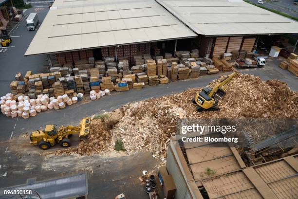 Front loader and excavator move scrap wood at a yard at the Gonoike Biomass Power Station, operated by Gonoike Bioenergy Corp., a subsidiary of...