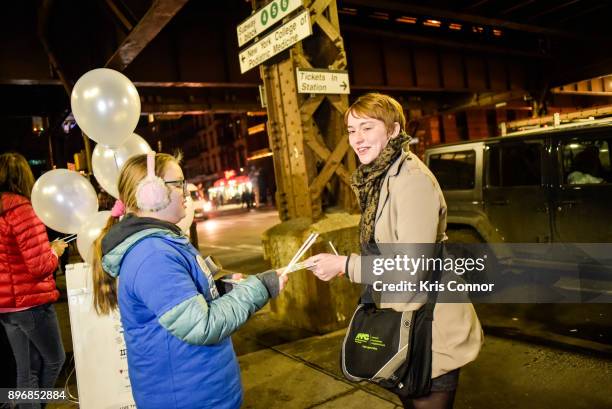 Meredith Krinkle hands out glow sticks during the "Solstice Soul Train" event as part of "Make Music Winter, December 21" on December 21, 2017 in New...