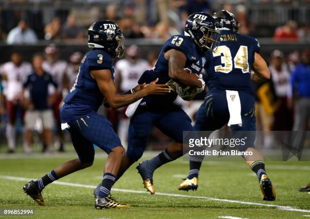 Quarterback Maurice Alexander of the Fiu Golden Panthers hands off to running back Napoleon Maxwell during the first quarter of the Bad Boy Mowers...